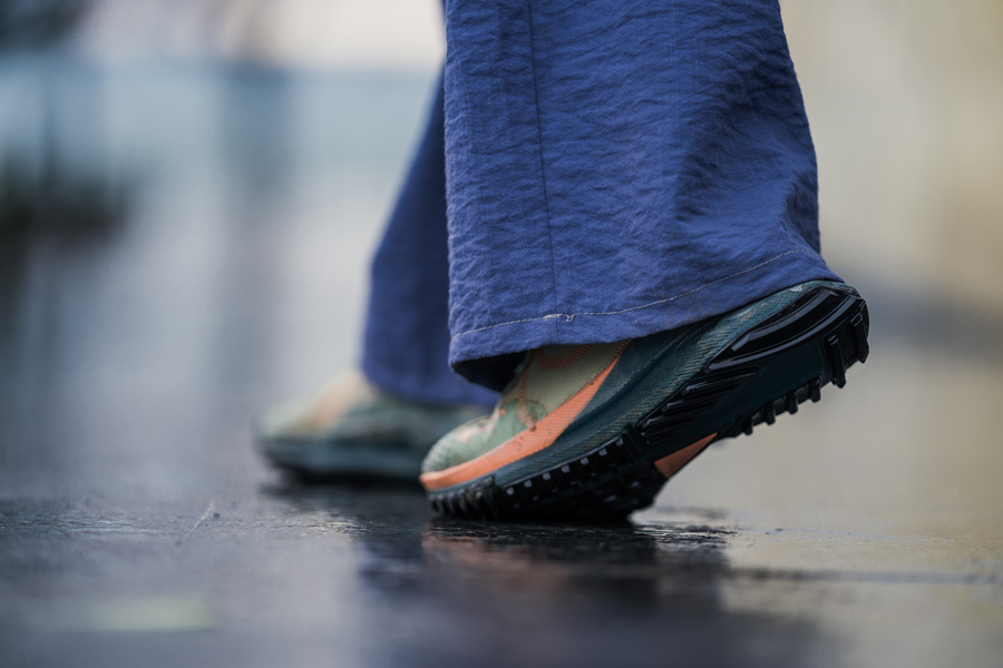 Person wearing grippy trainers and wide leg trousers in wet winter weather.